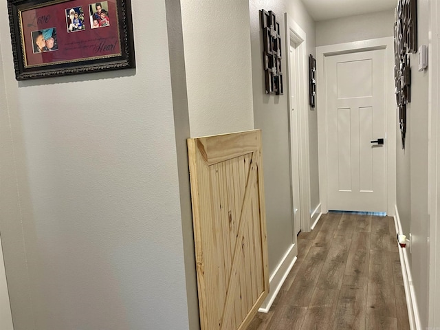 hall featuring baseboards and wood finished floors