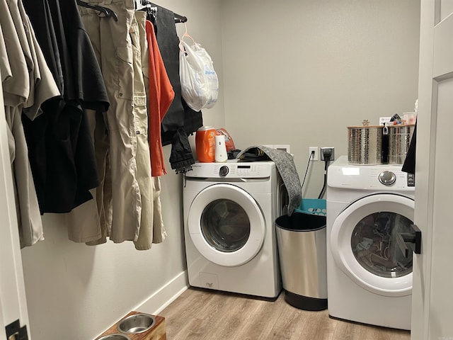 washroom with laundry area, light wood-style floors, independent washer and dryer, and baseboards