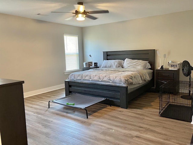 bedroom with ceiling fan, baseboards, visible vents, and wood finished floors