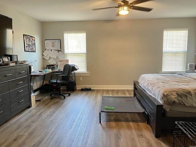 bedroom featuring a ceiling fan, baseboards, and light wood-type flooring