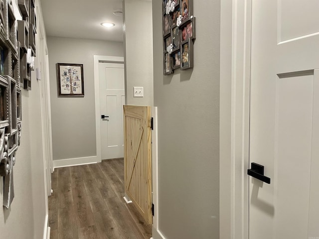 hall with dark wood-style flooring and baseboards