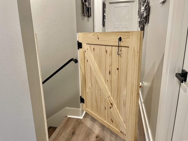 interior details with baseboards, a textured wall, and wood finished floors
