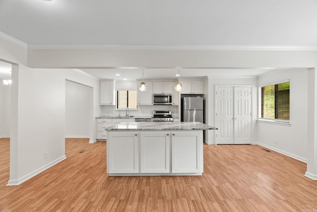 kitchen with appliances with stainless steel finishes, light wood finished floors, a center island, white cabinetry, and baseboards