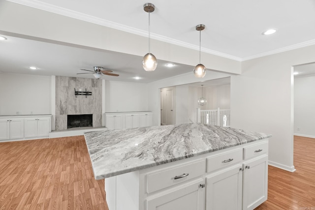 kitchen featuring white cabinets, ceiling fan, ornamental molding, and light wood-type flooring