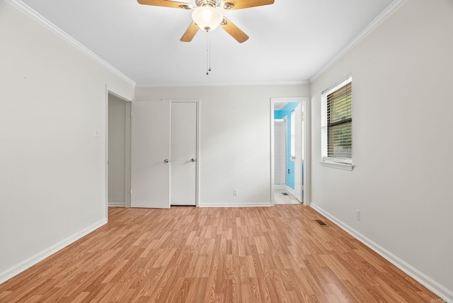 spare room featuring baseboards, ornamental molding, and light wood-style flooring