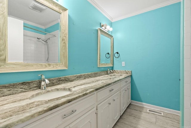 bathroom featuring a sink, ornamental molding, and visible vents