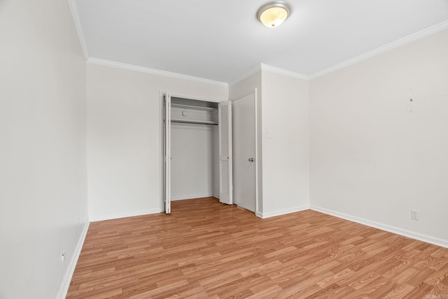 unfurnished bedroom with crown molding, baseboards, a closet, and light wood finished floors
