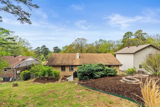 ranch-style home with fence, a chimney, a front yard, and brick siding