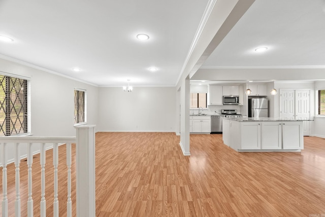 kitchen featuring crown molding, stainless steel appliances, a sink, and light wood-style floors