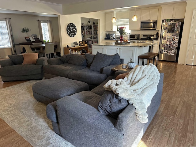 living room featuring dark wood-style floors, ornamental molding, and a toaster