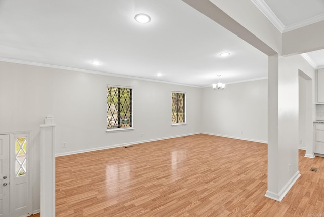 basement featuring baseboards, a chandelier, ornamental molding, and light wood-style floors