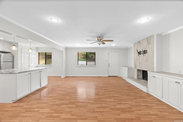 unfurnished living room with a fireplace, light wood-style flooring, a ceiling fan, recessed lighting, and ornamental molding