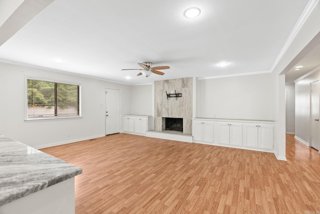 unfurnished living room with ceiling fan, ornamental molding, and light wood-style floors