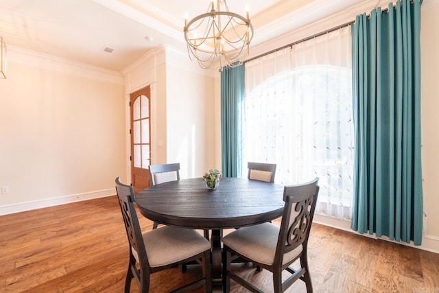 dining room featuring visible vents, ornamental molding, light wood-style floors, baseboards, and a notable chandelier