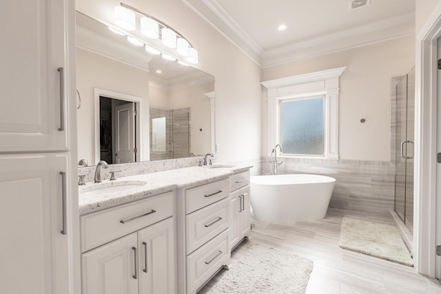 bathroom featuring double vanity, a sink, tile walls, and a shower stall