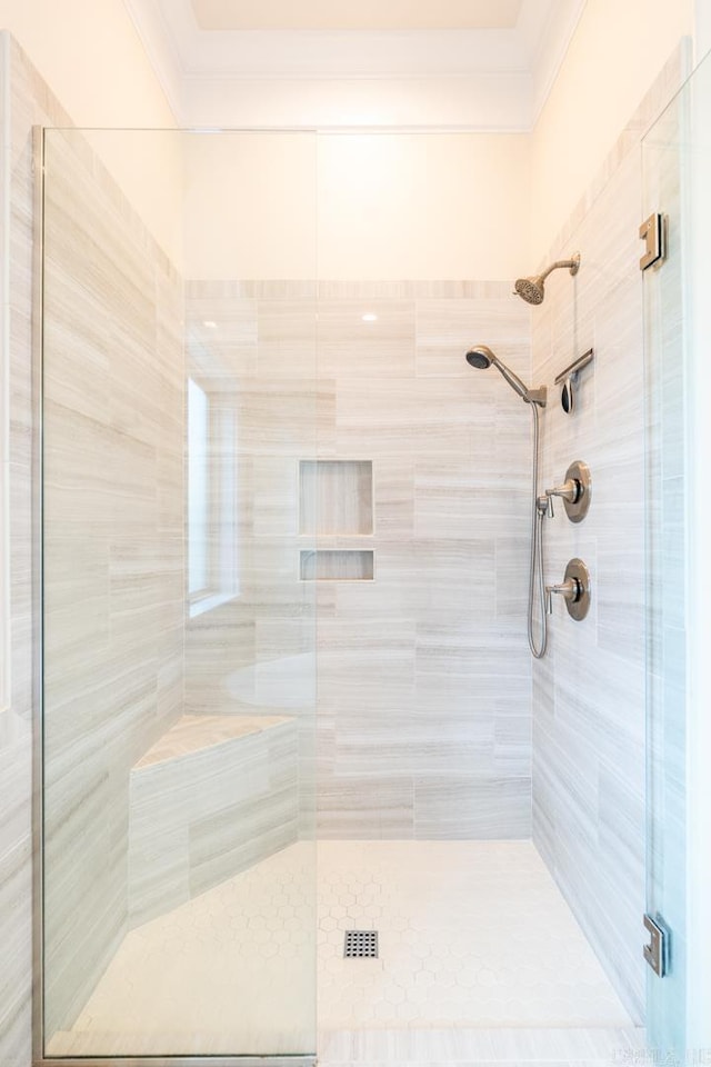 bathroom with ornamental molding and a shower stall