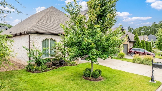 view of front of property featuring a garage, a front lawn, brick siding, a shingled roof, and concrete driveway