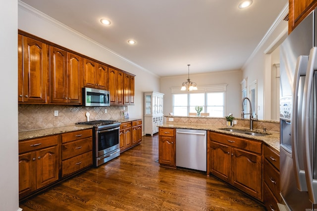 kitchen featuring a sink, appliances with stainless steel finishes, decorative backsplash, and a chandelier