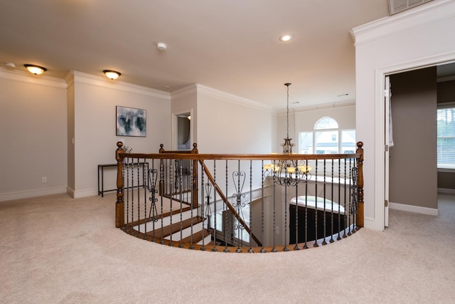 hall with carpet floors, baseboards, an upstairs landing, and an inviting chandelier