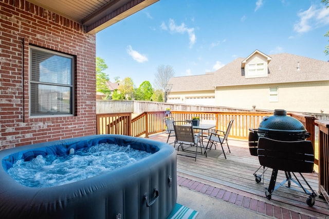 wooden terrace featuring a hot tub and outdoor dining space