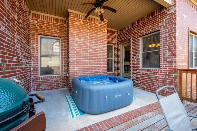 deck featuring a ceiling fan, a hot tub, and area for grilling