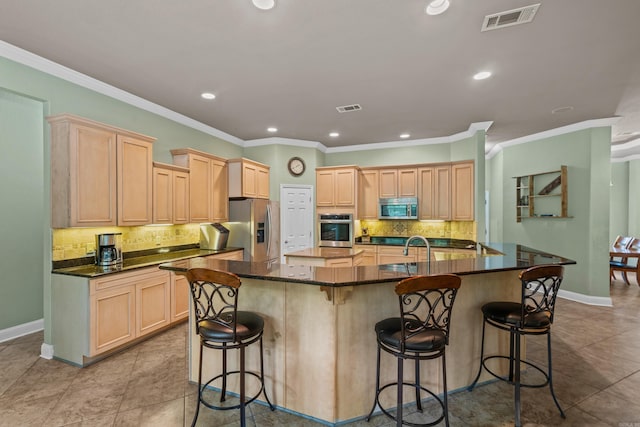 kitchen featuring light brown cabinetry, stainless steel appliances, and visible vents