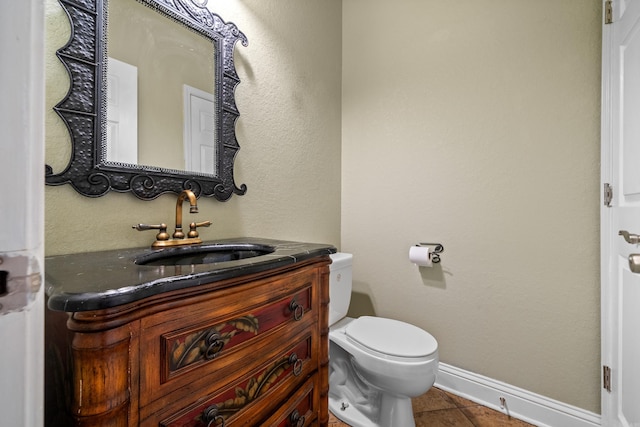 bathroom with tile patterned flooring, baseboards, toilet, and vanity