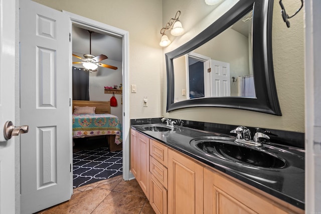 ensuite bathroom with a sink, ceiling fan, ensuite bath, and double vanity