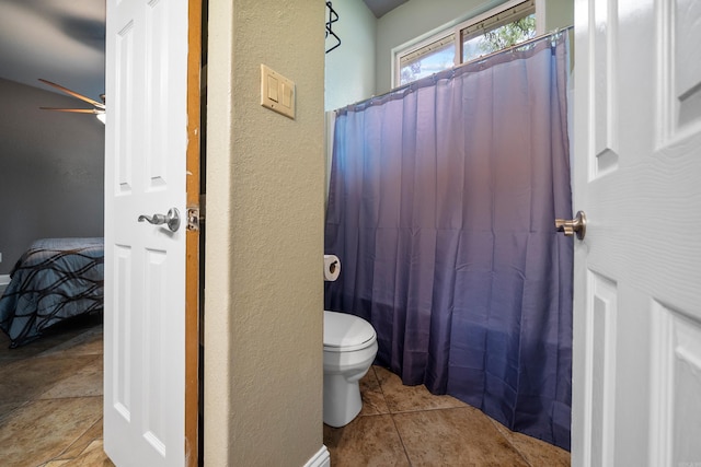 full bath featuring a textured wall, ceiling fan, toilet, and a shower with curtain