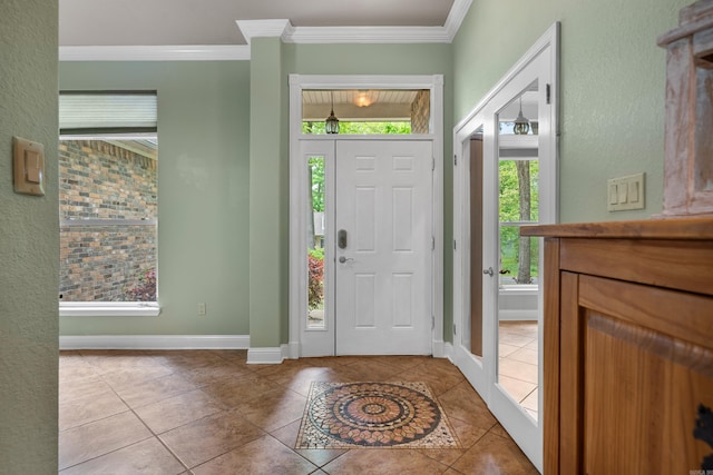 entrance foyer with crown molding, baseboards, and tile patterned flooring