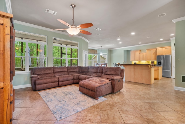 living room featuring baseboards, ceiling fan, ornamental molding, and visible vents