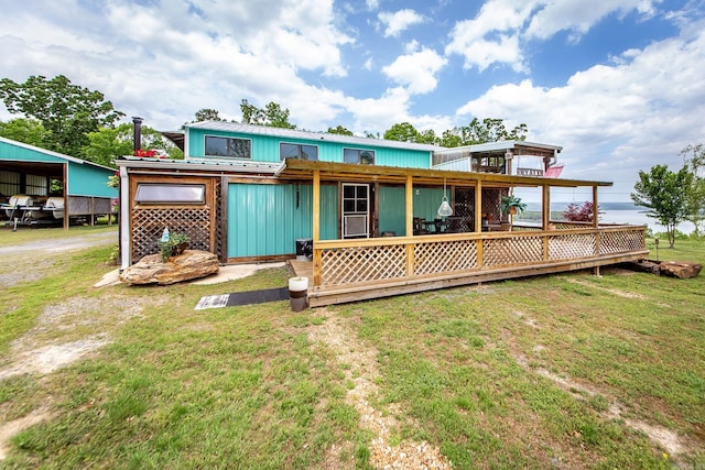4 Long Hill Rd, Higden, AR 72067 - rear view of house with a wooden deck, board and batten siding, a yard, and metal roof