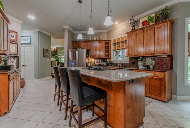 kitchen featuring brown cabinets, stainless steel appliances, light tile patterned flooring, and a center island