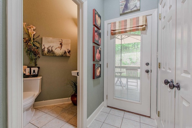 interior space featuring baseboards, tile patterned flooring, and toilet