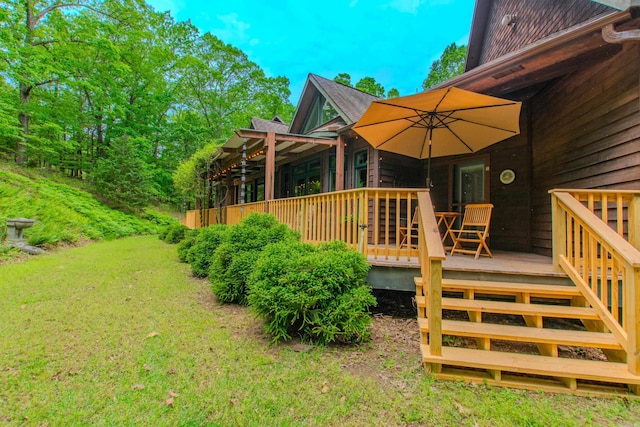 rear view of house with a lawn and a wooden deck