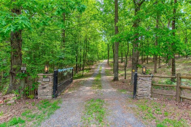 view of street with a gate and a view of trees