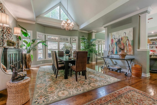 dining room featuring crown molding, vaulted ceiling, wood finished floors, baseboards, and a notable chandelier
