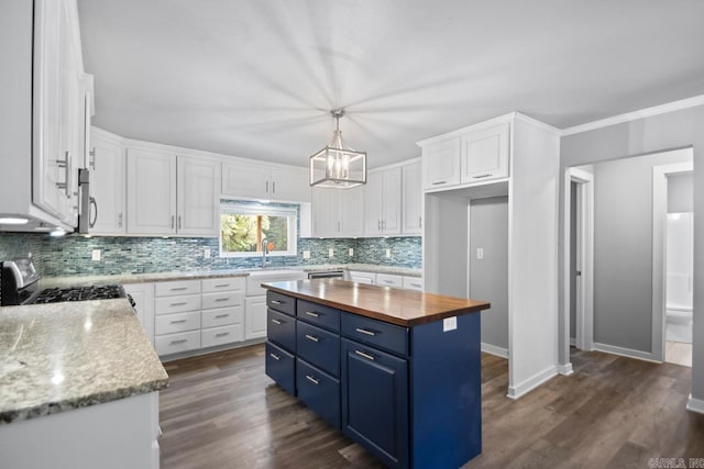 kitchen featuring stainless steel appliances, blue cabinets, butcher block counters, and white cabinetry