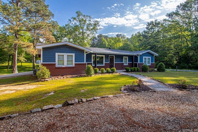 ranch-style house featuring covered porch, a front lawn, and brick siding