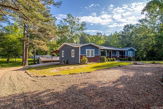view of front of home featuring brick siding, driveway, and a front yard