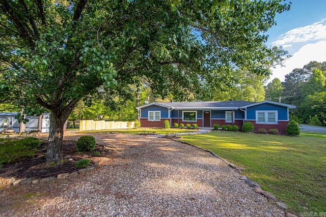single story home featuring fence, a front yard, gravel driveway, and brick siding