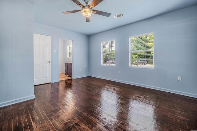 unfurnished room with ceiling fan, visible vents, baseboards, and hardwood / wood-style flooring