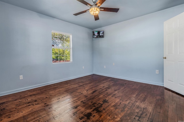 unfurnished room featuring baseboards, dark wood finished floors, and ceiling fan