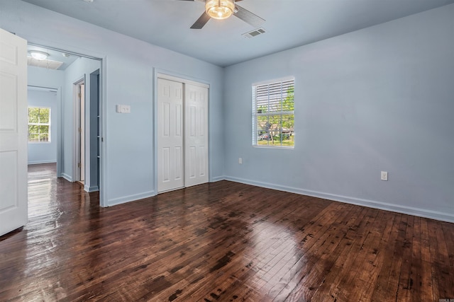 unfurnished bedroom featuring baseboards, visible vents, dark wood-style floors, and a closet