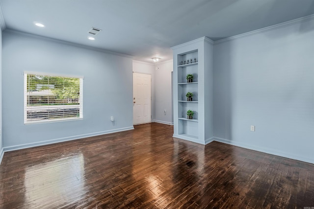 unfurnished room with visible vents, crown molding, built in features, hardwood / wood-style flooring, and baseboards