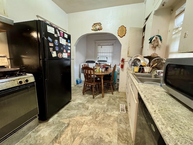 1519 S Oak St, Little Rock, AR 72204 - kitchen featuring arched walkways, dishwasher, light countertops, stainless steel microwave, and range with gas stovetop