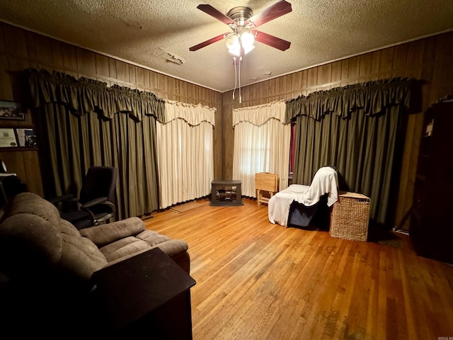 1519 S Oak St, Little Rock, AR 72204 - living area featuring a textured ceiling, ceiling fan, wood walls, and wood finished floors