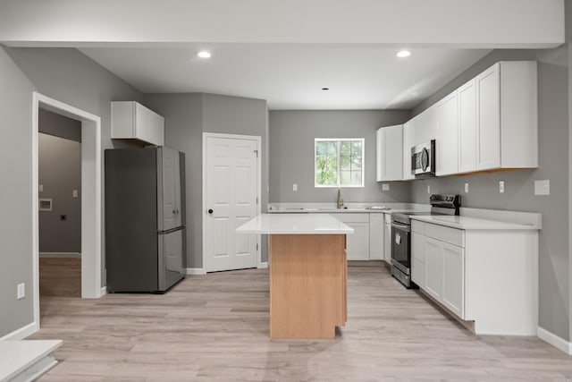 609 S St, Hot Springs, AR 71913 - kitchen featuring appliances with stainless steel finishes, light wood finished floors, light countertops, a center island, and baseboards