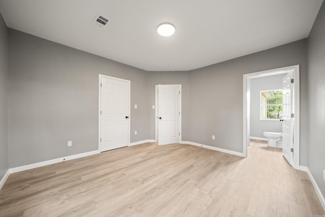 609 S St, Hot Springs, AR 71913 - unfurnished bedroom featuring visible vents, light wood finished floors, ensuite bathroom, and baseboards