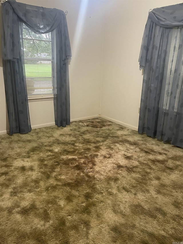 carpeted empty room with baseboards